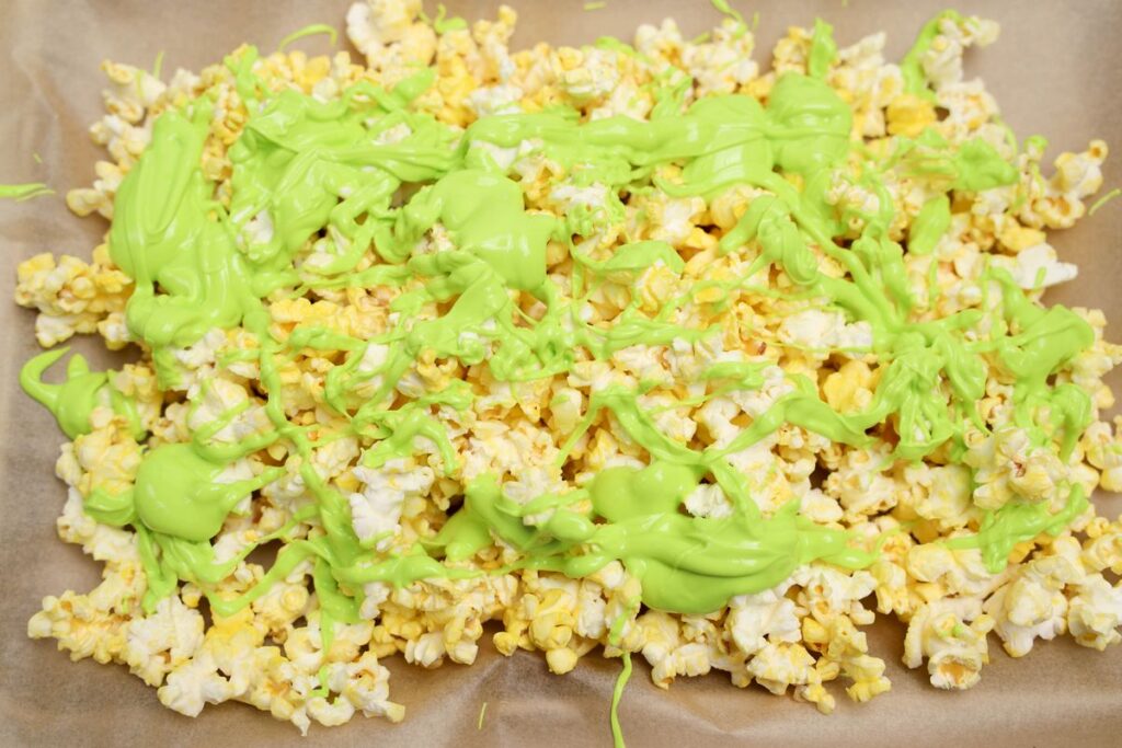 Summerween Horror Popcorn with green drizzled neon candy melts.